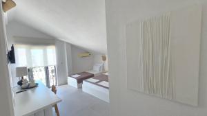 a white living room with a couch and a table at Vele House Walk to Beach in Herceg-Novi