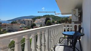 a table and chair on a balcony with a view at Vele House Walk to Beach in Herceg-Novi