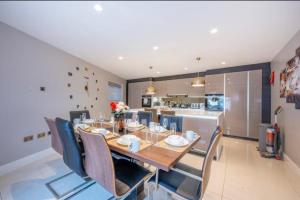 a dining room with a table and chairs and a kitchen at RA7C Stylish Loft Stay in Batley