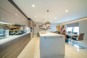 a large kitchen with a counter and a dining room at RA7C Stylish Loft Stay in Batley +8 photos