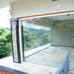 a large window in a room with a view at Sindu Homestay in Kalasa