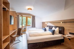 a bedroom with a bed and a desk and a chair at Ferienwohnungen Luxner in Gerlos
