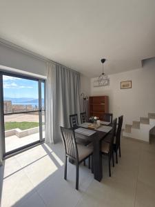 a dining room with a table and chairs and a window at Elements Villas in Paleros