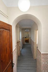 a hallway with an archway and a wooden door at F3 SALAMANDRE à CORNICHE CASA MAZA in Mostaganem