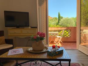 a living room with a table with a vase of flowers at Les Oliviers in Grimaud