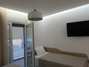 a bedroom with a bed and a flat screen tv at Gatos Beach in Pefkochori