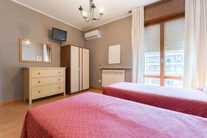 a bedroom with two beds and a dresser and a window at Affittacamere Pizzeria Ristorante Treppì in Caldiero
