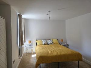a bedroom with a bed with a yellow blanket at Charming Wootton in Hail Weston
