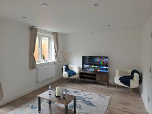 a living room with a tv and a table at Charming Wootton in Hail Weston
