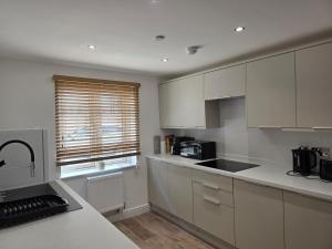 a kitchen with white cabinets and a counter top at Charming Wootton in Hail Weston