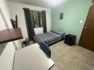 a small room with a bed and a chair at Habita Coliving La Palma in Medellín