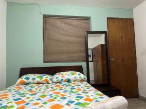a bed with a colorful comforter in a bedroom at Habita Coliving La Palma in Medellín +8 photos
