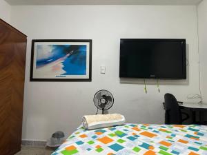 a bedroom with a flat screen tv and a bed at Habita Coliving La Palma in Medellín