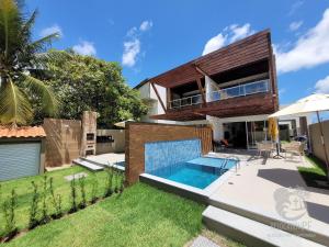a villa with a swimming pool and a house at Vila Sol Serrambi in Porto De Galinhas