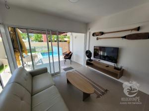a living room with a couch and a flat screen tv at Vila Sol Serrambi in Porto De Galinhas