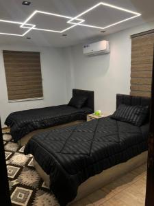 a room with three beds and a air conditioner at Green forest farm in Ajloun