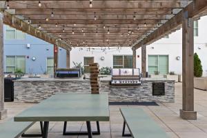 an outdoor patio with a wooden pergola and a table at Spacious 2BR N Gulch Walk to Broadway & Rooftops in Nashville