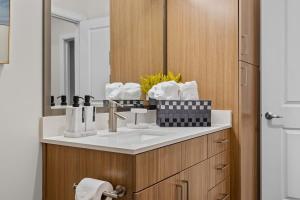 a bathroom with a sink and a mirror at Spacious 2BR N Gulch Walk to Broadway & Rooftops in Nashville