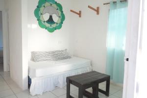 a small bedroom with a bed and a stool at Mojo Surf House in Popoyo