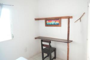 a wooden shelf on a wall with a chair at Mojo Surf House in Popoyo