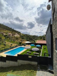 a view of a swimming pool with umbrellas at Casa Resineiro com Piscina, Garagem e Terraço in Proença-a-Nova