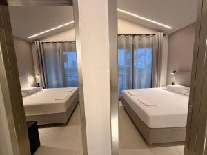 a small bedroom with two beds and a window at LaK Private Pool Suites in Potos,Thassos in Potos +33 photos