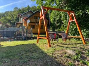 an orange swing set in the yard of a house at Brvnarica na reci in Brus