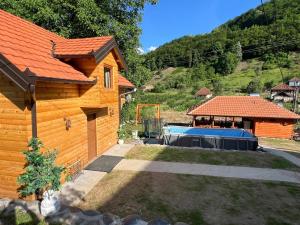 a wooden house with a pool in the yard at Brvnarica na reci in Brus