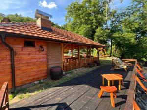 a cabin with a table and a bench on a deck at Brvnarica na reci in Brus