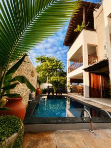 a swimming pool in front of a house at Condomínio Harmonia in Pipa