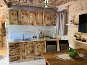 a kitchen with wooden cabinets and a wooden table at Brvnarica na reci in Brus