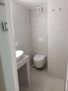 a white bathroom with a toilet and a sink at Gatos Beach in Pefkochori +15 photos