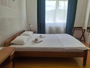 a bed in a room with a window and two towels at Motel Buče in Berane