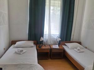 two twin beds in a room with a window at Motel Buče in Berane