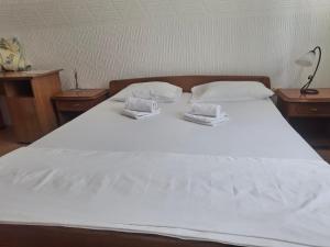 a large white bed with two white towels on it at Motel Buče in Berane