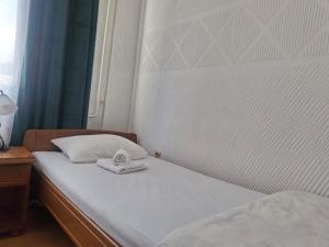 a bed with two towels sitting on top of it at Motel Buče in Berane