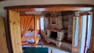 una camera da letto con un letto e un camino in pietra di Castello Bellos Tower a Keríon