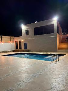 a swimming pool in front of a building at night at Green forest farm in Ajloun