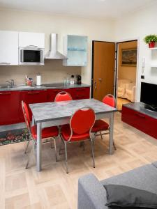 a kitchen with a table and red chairs at Maison Belle Vue in Chioggia