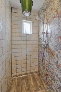 a bathroom with a shower with a window at Be my Guest House in Wijk aan Zee