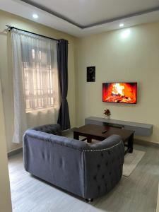 a living room with a couch and a table at Rosebank Villas in Luanda