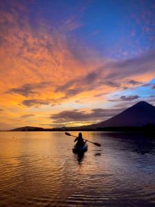 a person in a kayak on a lake at sunset at Sunny Garden Lodge in Mérida