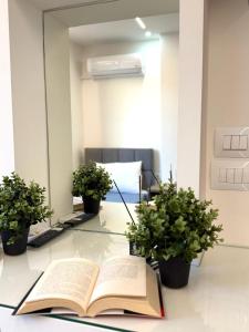 an open book on a desk with two potted plants at Aura Rooms in Delvinë