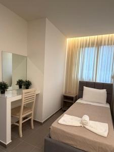 a bedroom with a bed and a desk and a mirror at Aura Rooms in Delvinë