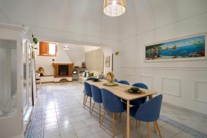 a dining room with a table and blue chairs at The Lemon Garden Escape in Meta