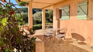 a patio with a table and chairs in front of a house at Les Oliviers in Grimaud