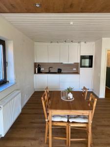 a kitchen and dining room with a wooden table and chairs at Casa Piedra in Kleinsteinhausen