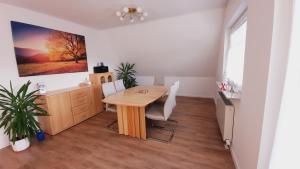 a dining room with a table and a desk at Ferienwohnung Bandow in Woltersdorf