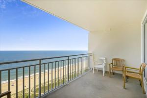 a balcony with two chairs and a view of the beach at Carousel 1904 in Ocean City +24 photos