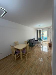 a living room with a table and chairs and a couch at Elois Apartments in Shëngjin